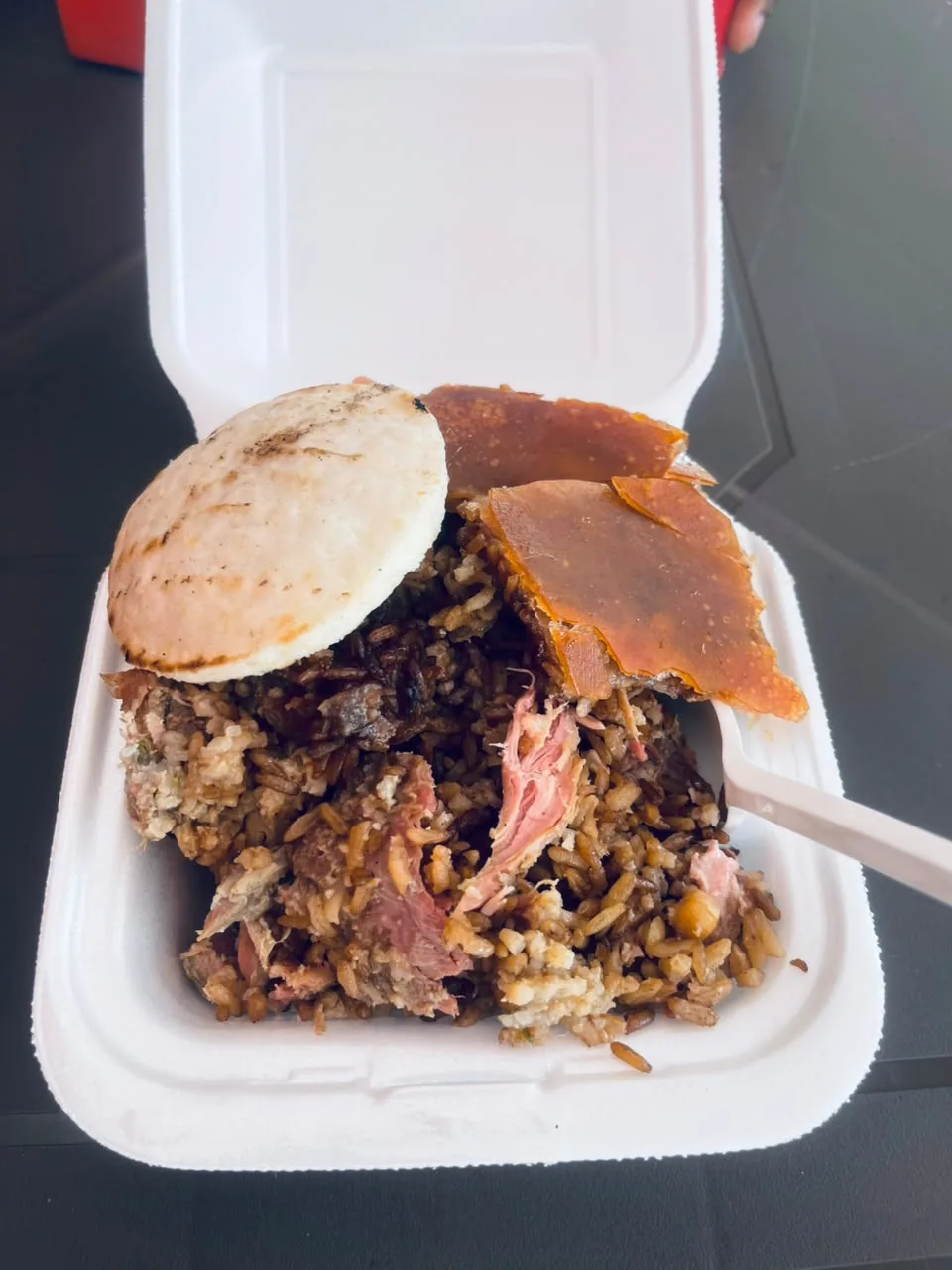 Porción de Lechona JG para llevar, con el cuero crocante, arroz relleno, carne de cerdo y arepa